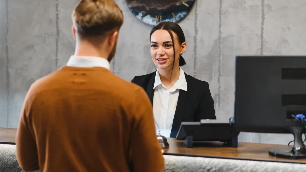 A guest checking in at a hotel front desk